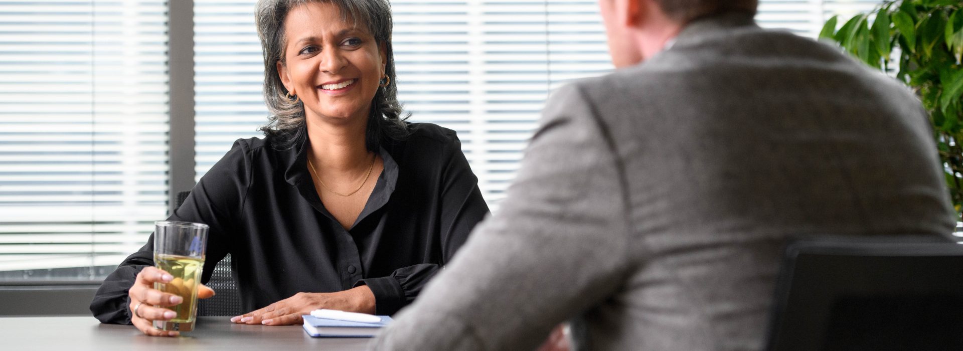 Twee managers zitten aan tafel, met elkaar in gesprek