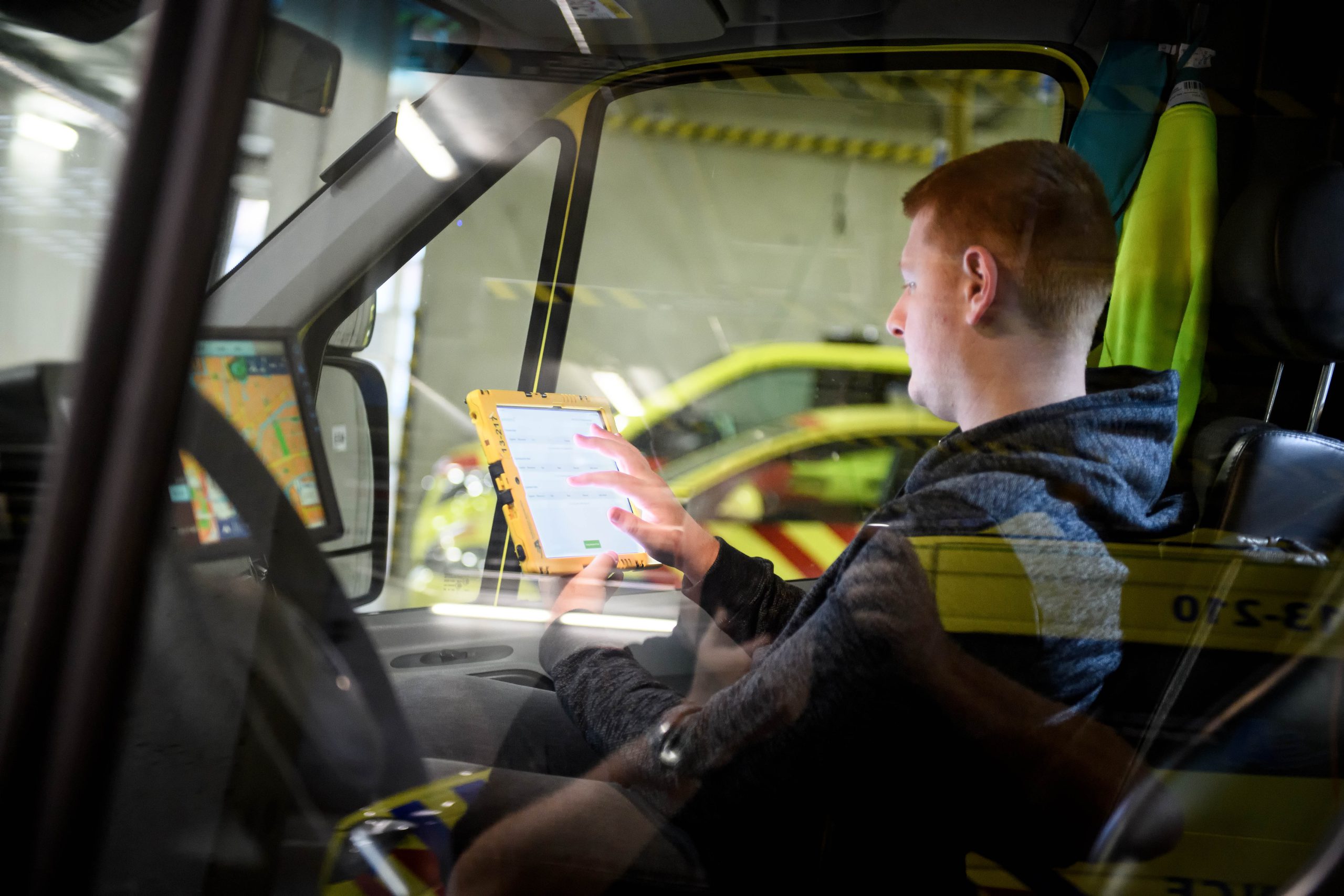 ICT-medewerker zit in de ambulance de tablet in te stellen die ambulanceprofessional gebruiken