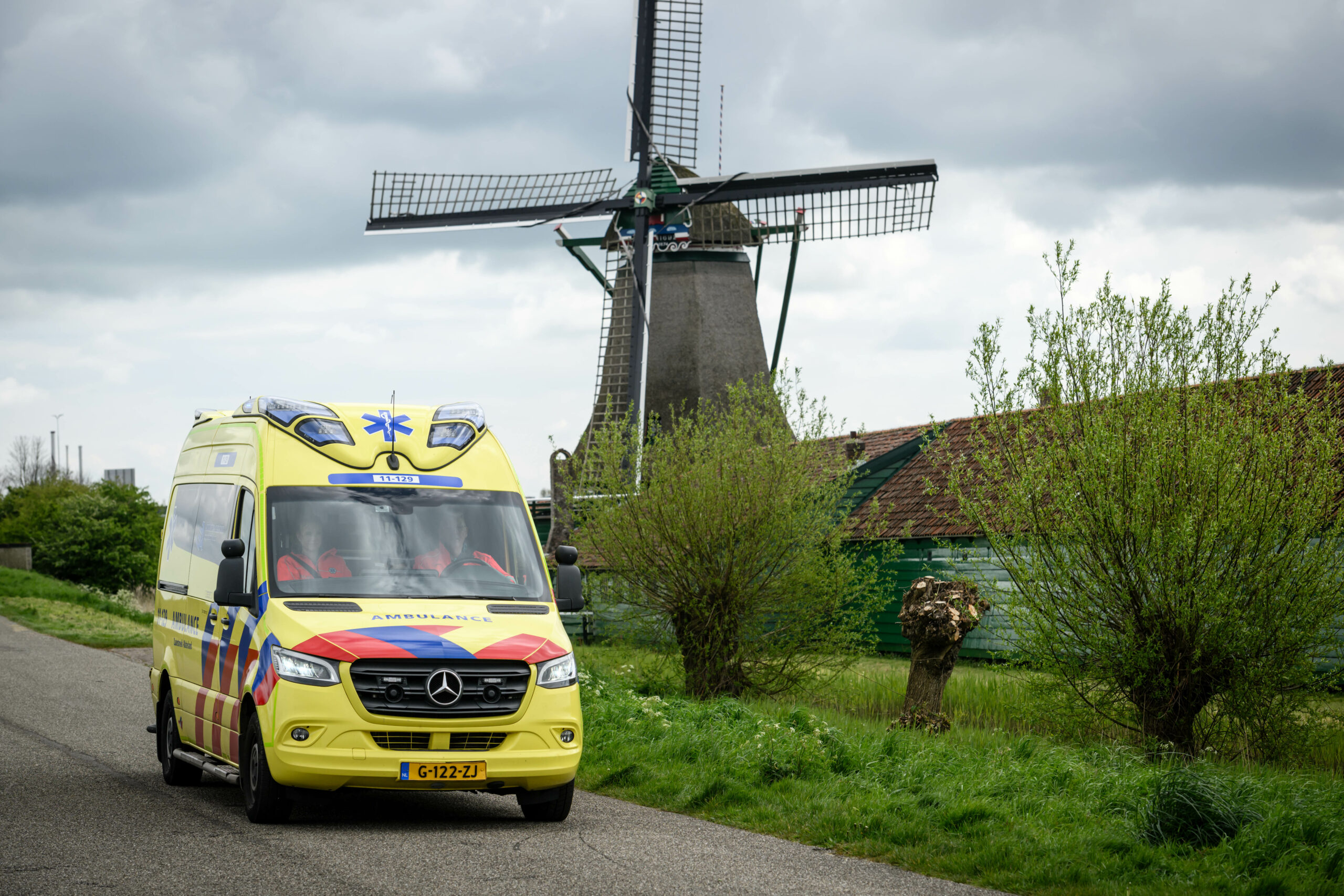 Ambulance rijdt langs een molen