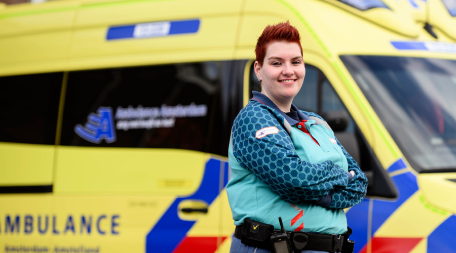 Verpleegkundige poseert voor ambulance