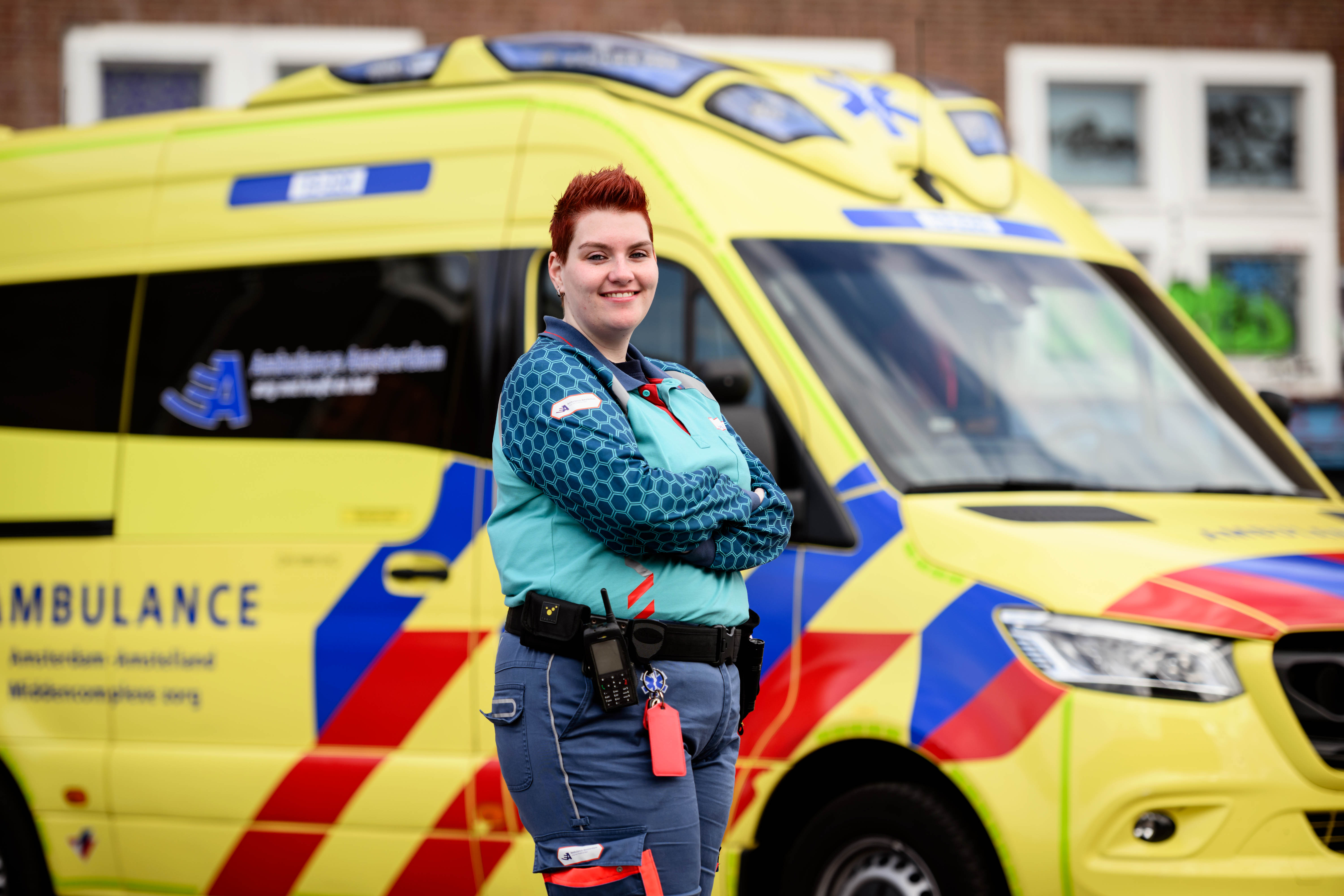 Verpleegkundige poseert voor ambulance