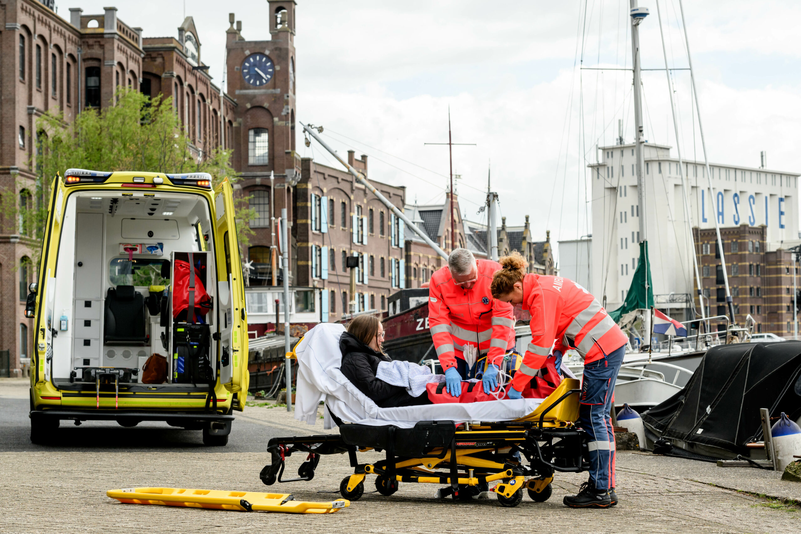 Een ambulanceteam behandelt een patiënt op een brancard op de Veerdijk in Wormer.
