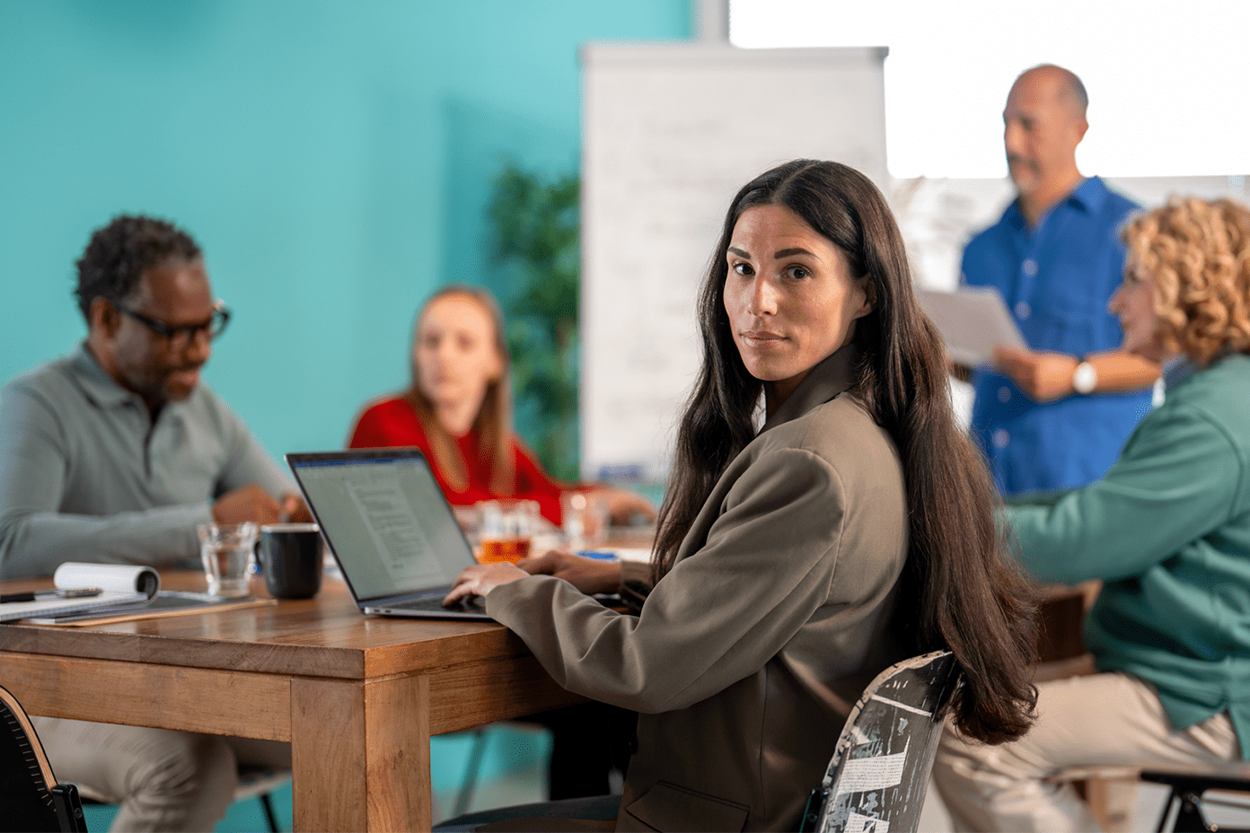 Een collega zit achter haar computer, in een meeting