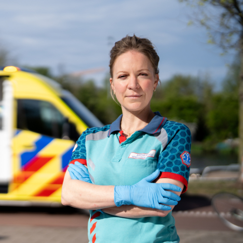 Ambulancemedewerker poseert voor ambulance